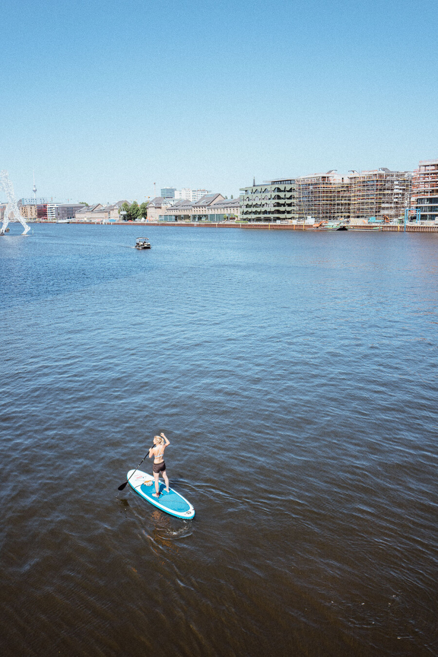 A woman on a stand up paddle on the Spree river